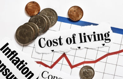 Coins rest on rising graph and cost of living headlines